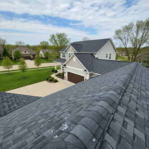 New impact-resistant asphalt shingle roof on a Missouri home with hailstones on the surface